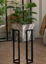 Luxury modern marble planter stand with black metal legs holding gold textured vases